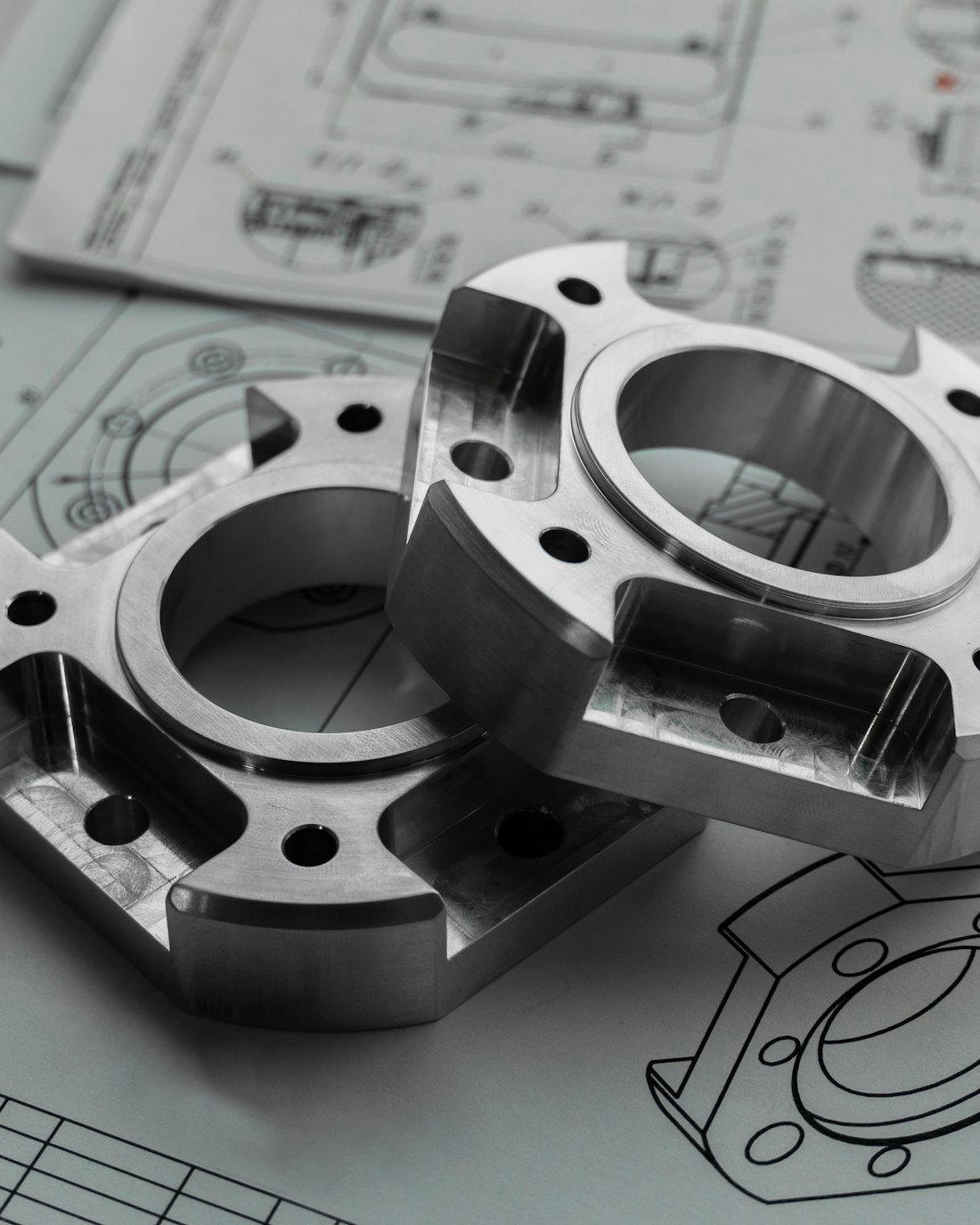 Precision-machined defense components resting on their engineering drawings